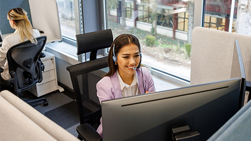 two people at desk one with headset