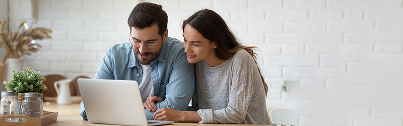 couple in kitchen looking at laptop