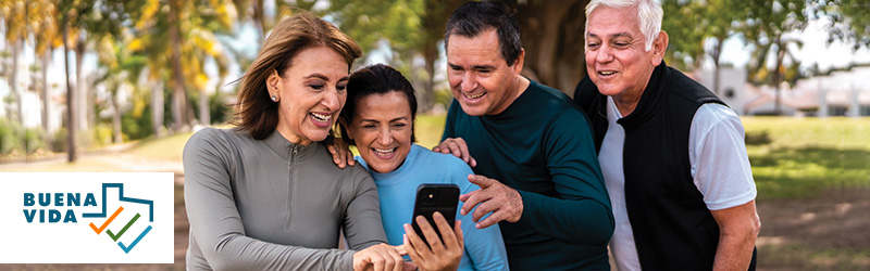 retirees in park looking at mobile phone and Buena Vida logo