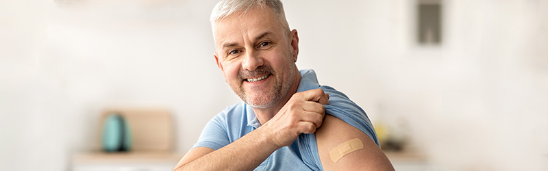 man with sleeve up showing band aid