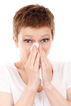 woman holding tissue at her nose