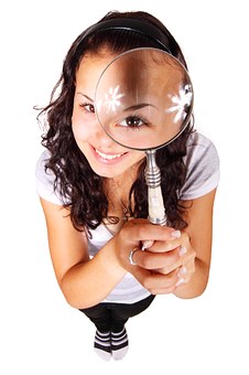 eye doctor holding magnifying glass over her left eye