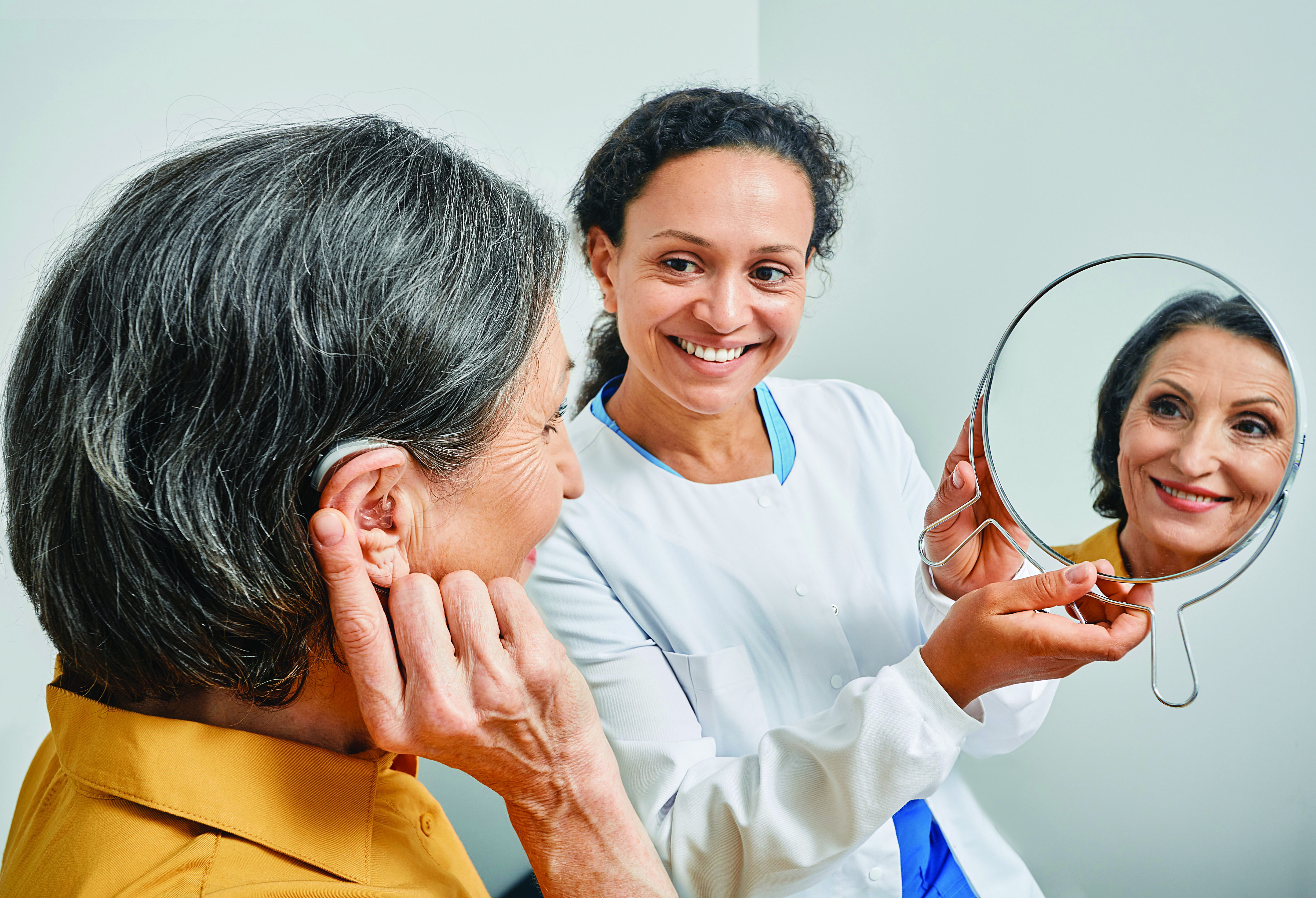 older woman being fitted for hearing aid