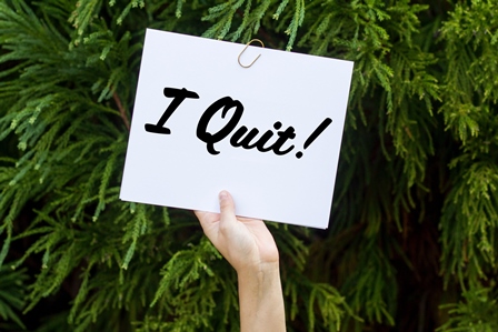 hand holding up sign that says "I quit!"