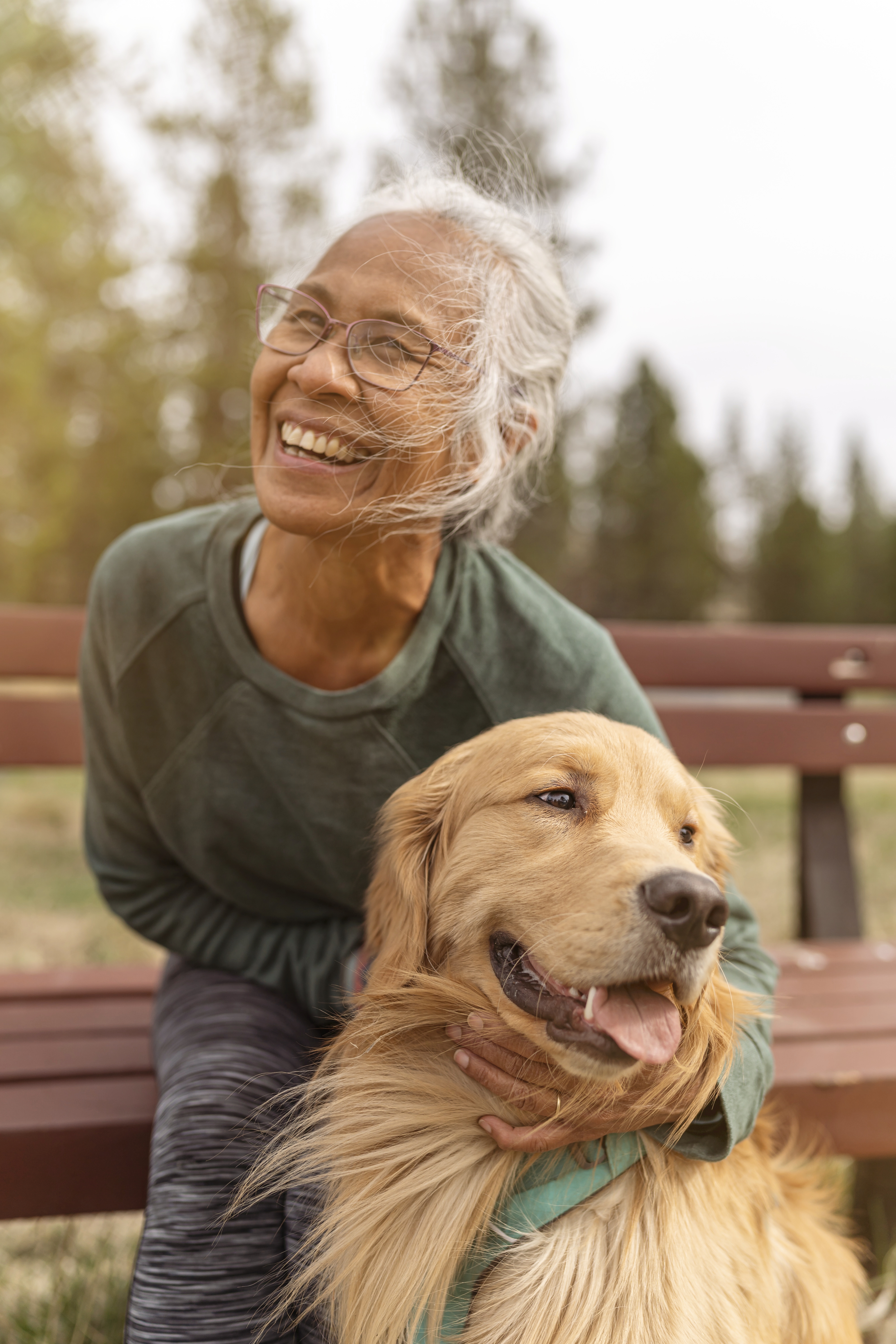 older smiling woman hugging dog